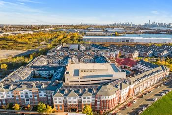 an aerial view of houses in front of a body of water and a cityat Harbor Pointe, New Jersey, 07002